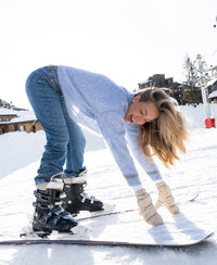 Light blue mohair sweater in a relaxed fit, shown on a woman bending forward and smiling.
