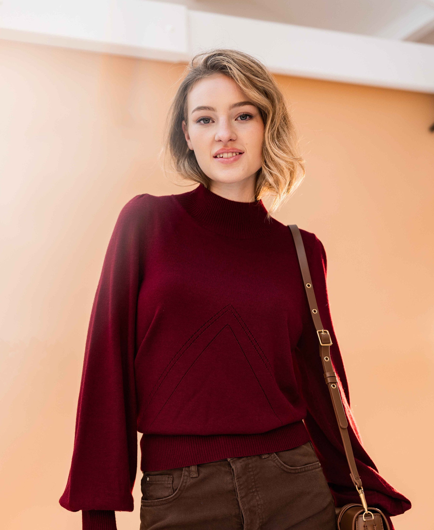 Woman wearing a dark red LES SALLES turtleneck sweater by PLEIN PUBLIQUE.