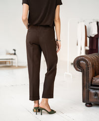 Person wearing PLEIN PUBLIQUE 7/8 LE FAUBOURG pants in pure chocolate color.