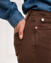 Person wearing brown flared jeans, hand in pocket.