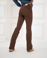 Brown flared jeans, shown from the back, in a white room.