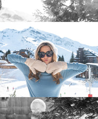 Woman wearing a blue Merino wool turtleneck sweater stands in the snow.