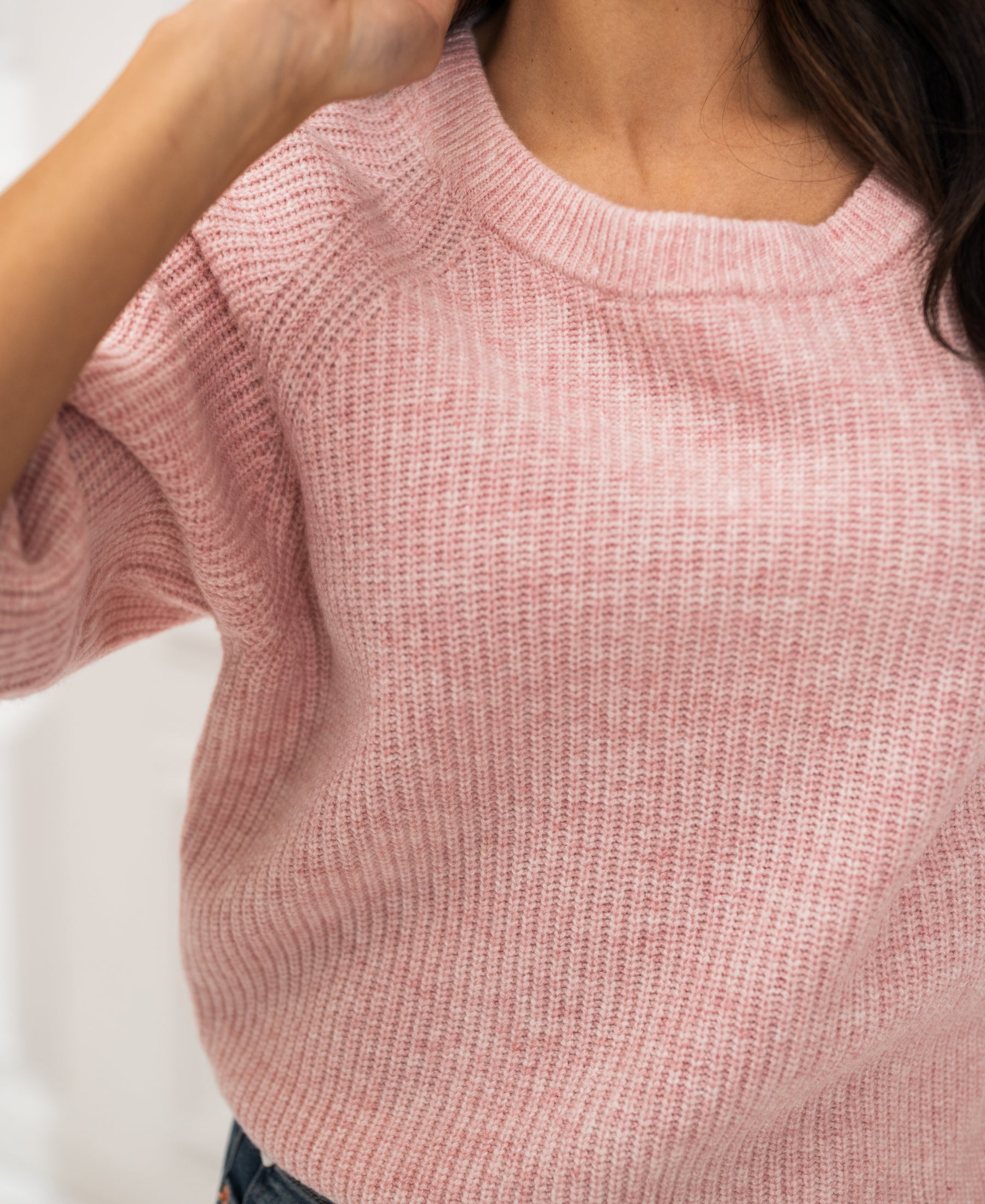 Pink raspberry knit sweater shown from shoulders to waist.
