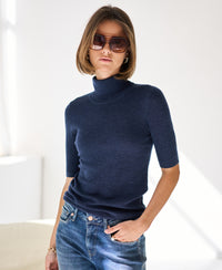 Short-sleeve blue turtleneck sweater displayed in a bright room.