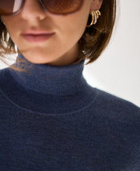 Short-sleeve turtleneck sweater in blue from lips to chest visible.