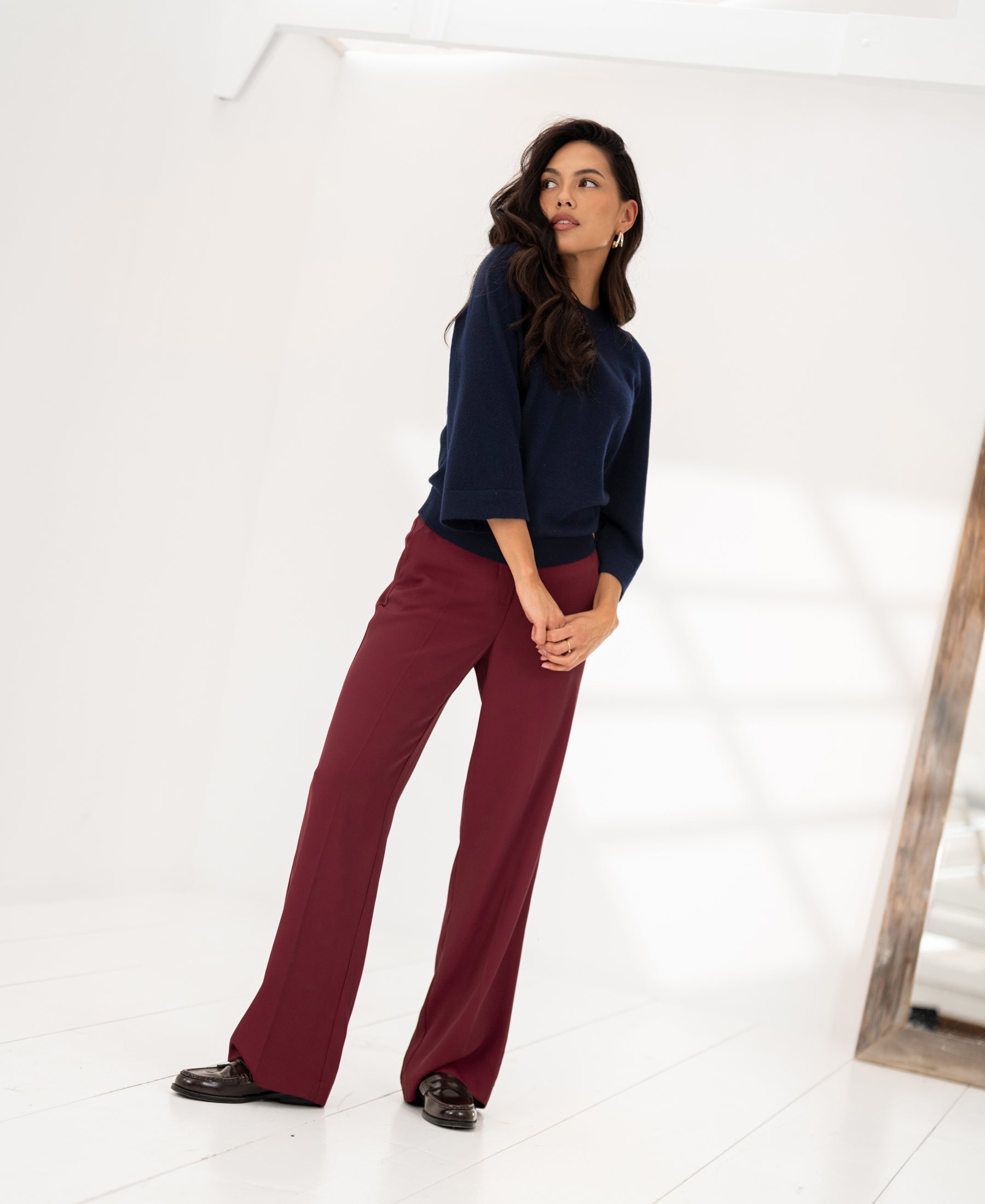 Woman wearing a dark blue merino wool sweater by PLEIN PUBLIQUE.