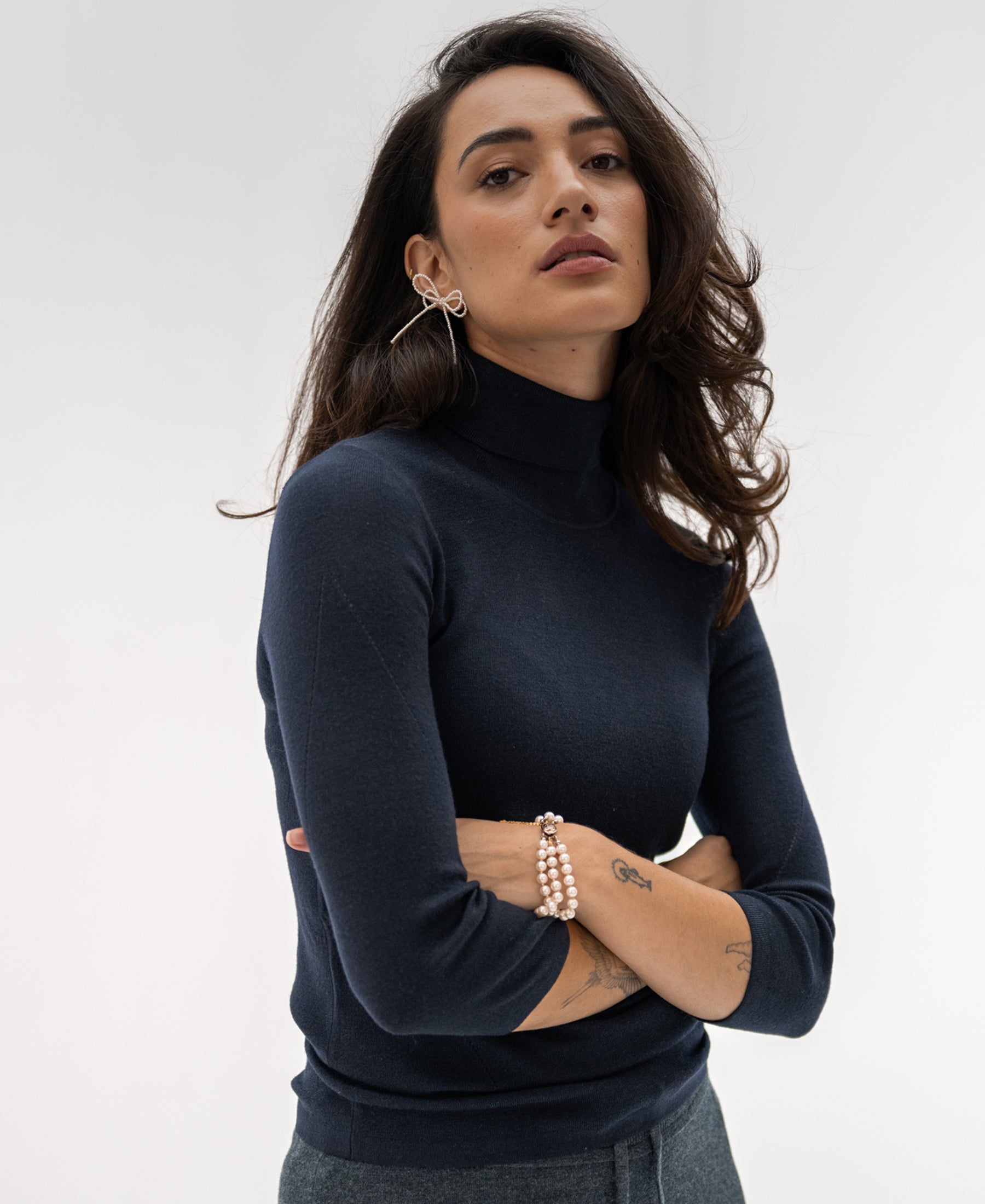 Woman wearing dark blue turtleneck sweater.