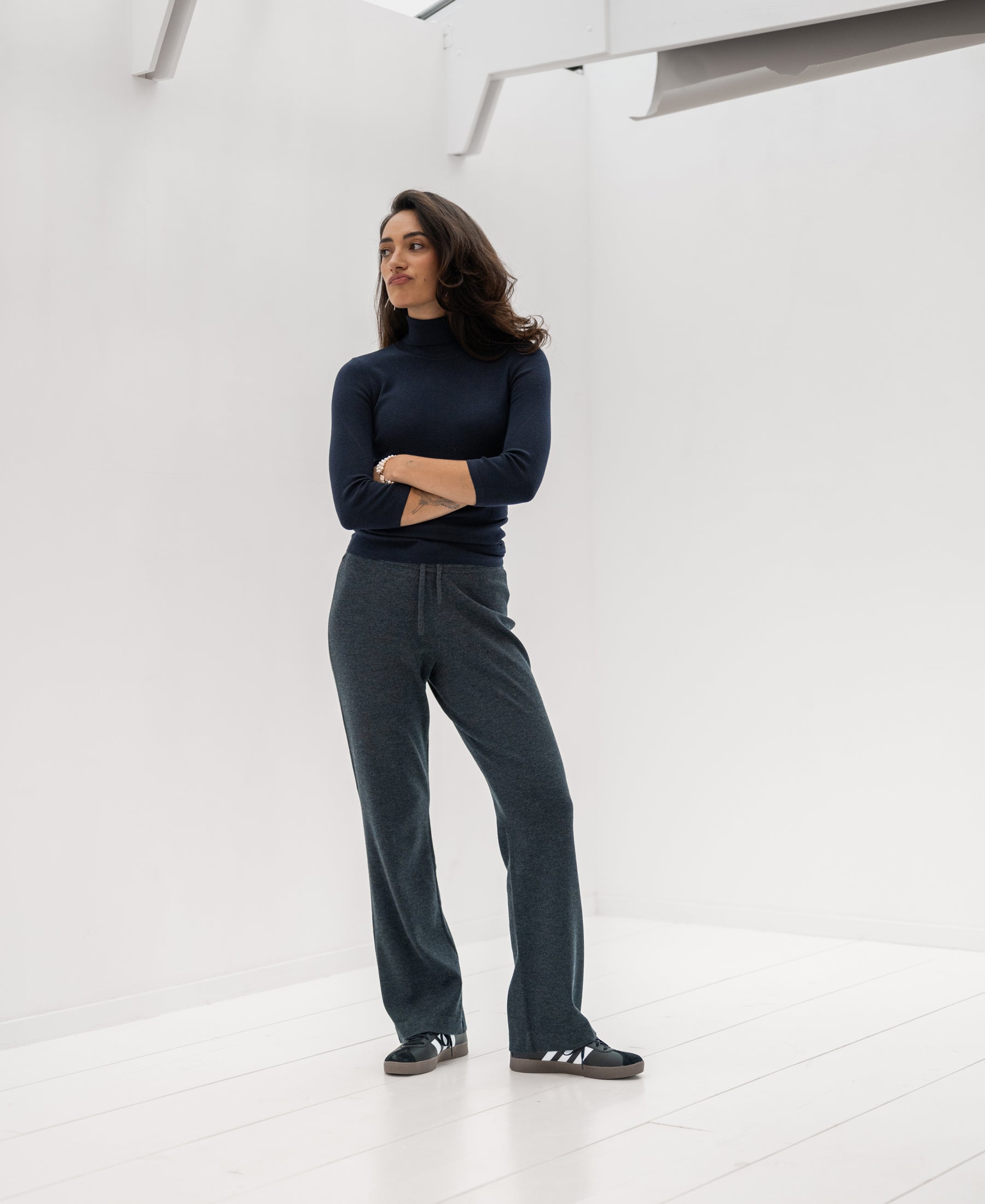 Woman wears the PLEIN PUBLIQUE LE FABIAN dark blue turtleneck sweater indoors.