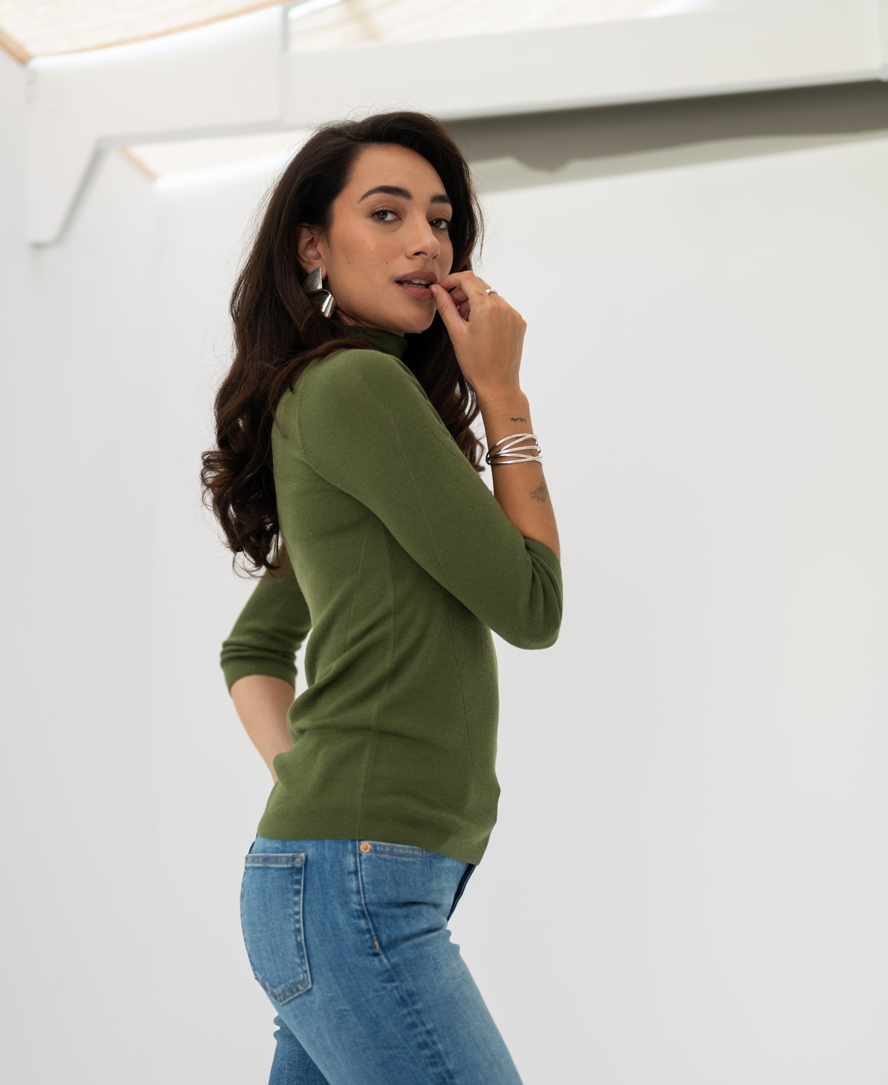 Olive green LE FABIAN turtleneck sweater by PLEIN PUBLIQUE shown from the side against a light background.