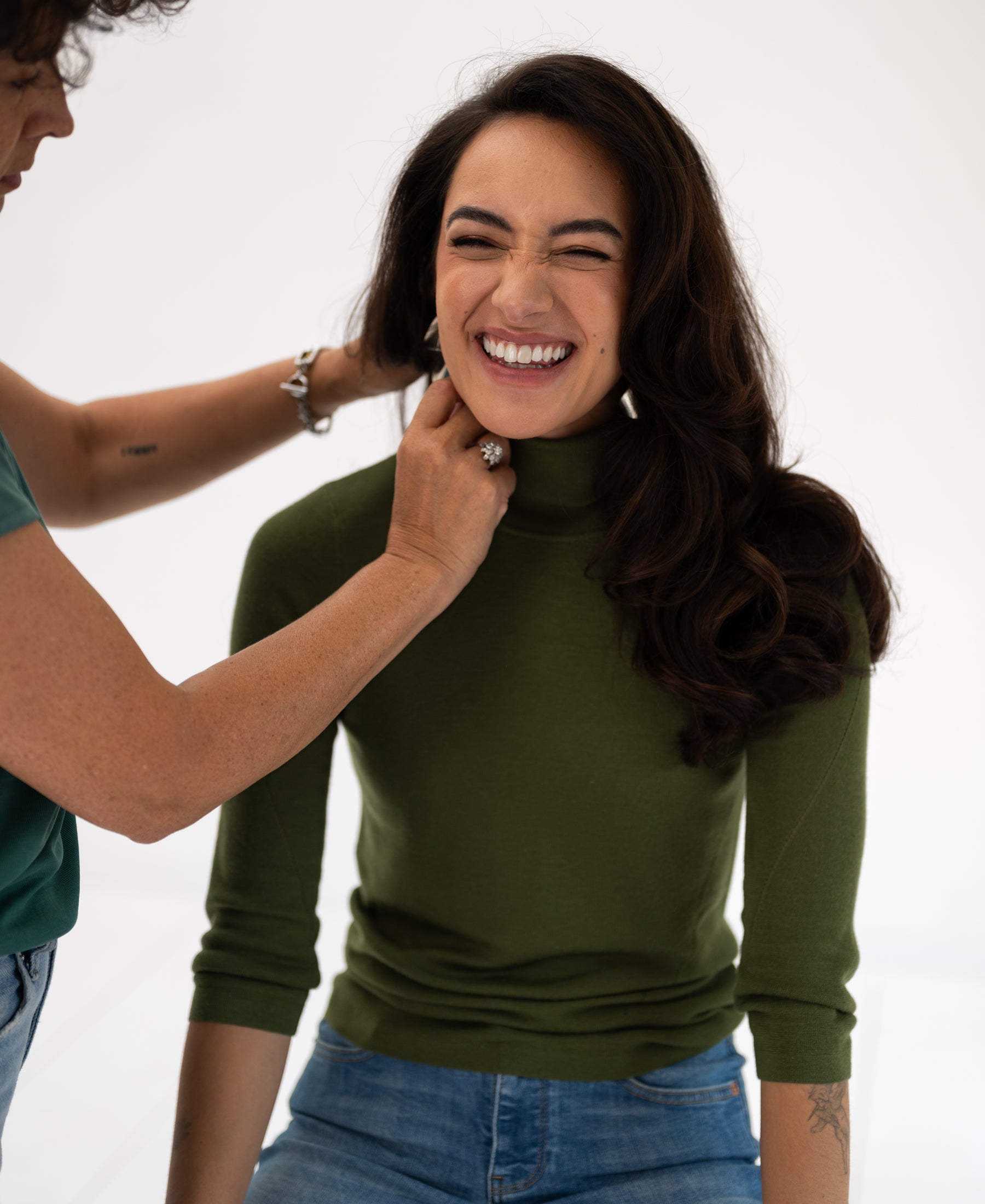 An olive green turtleneck sweater displayed against a white background.
