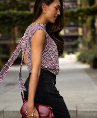 Woman wearing PLEIN PUBLIQUE Polka Dot Blouse Top LA GIVERNY Wine-Ivory standing outdoors on a sunny day.