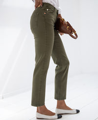 Model wears army green cropped jeans on a white backdrop.