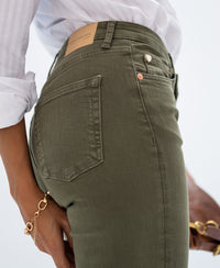 Model wearing army green cropped jeans; hand near back pocket.