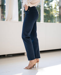 Dark blue cropped jeans displayed indoors in sunlight.