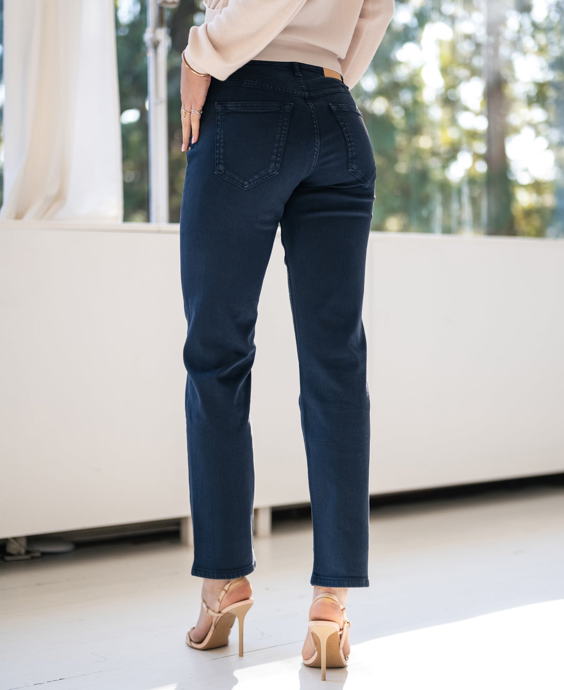 Woman wearing PLEIN PUBLIQUE cropped jeans in dark blue (Le Guy Donkerblauw), standing indoors in sunlight.