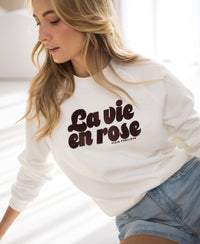 Ivory and cacao LA HARPER sweater by PLEIN PUBLIQUE worn by a woman with long blonde hair, shown indoors.