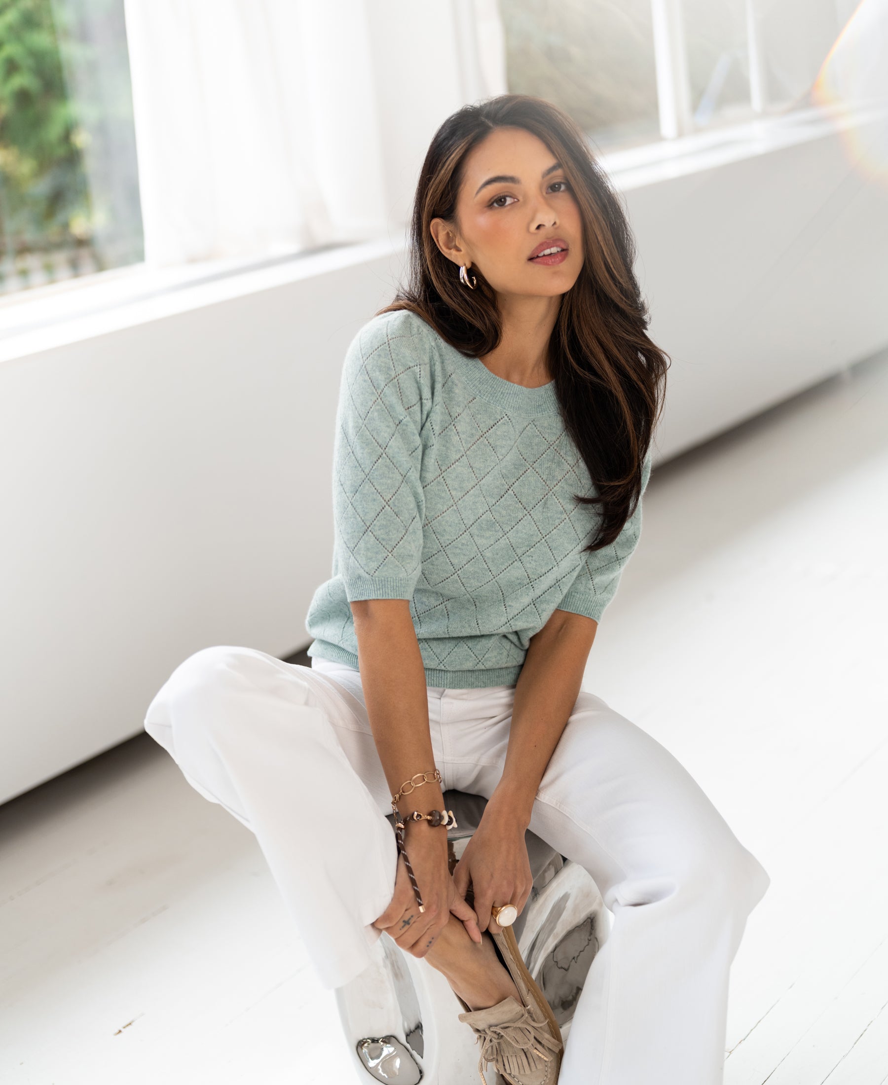 Light green argyle merino wool sweater shown in a bright room.