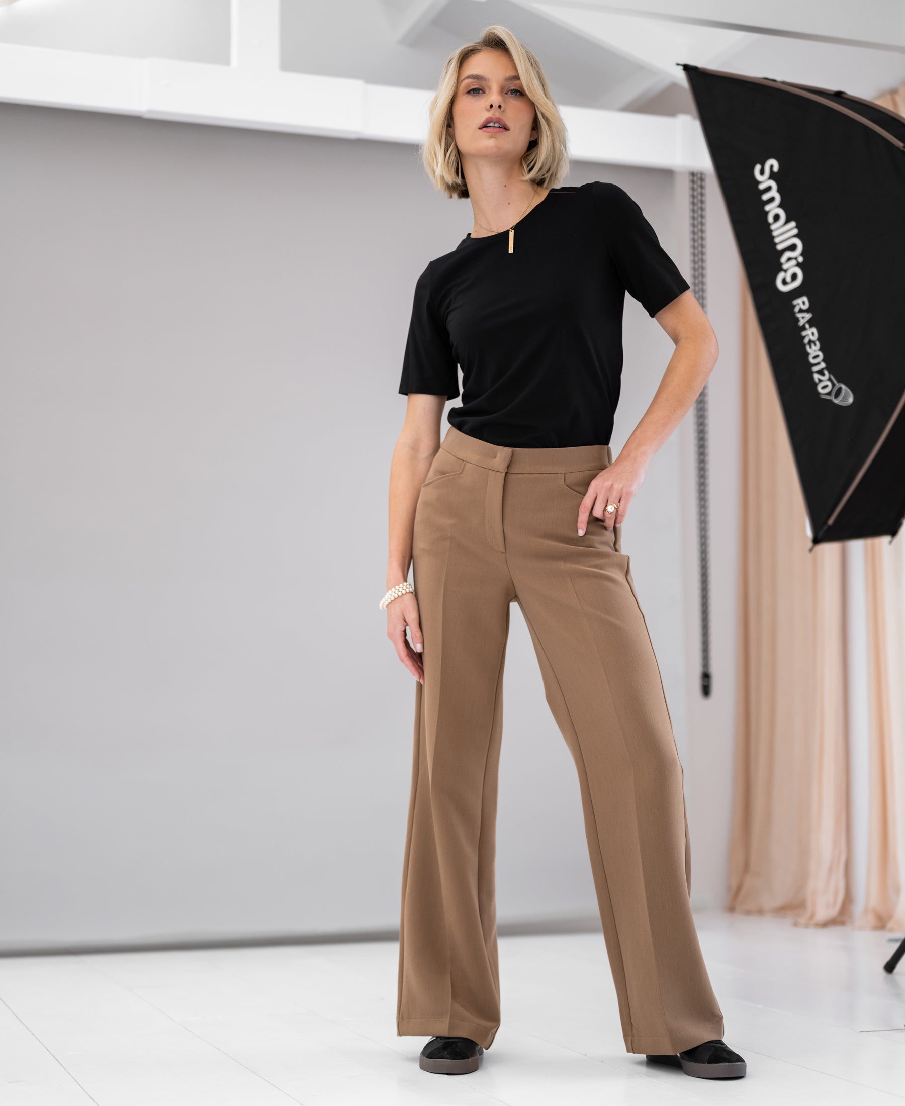 Front view of woman wearing the Plein Publique black travel T-shirt Le Favory in a studio.