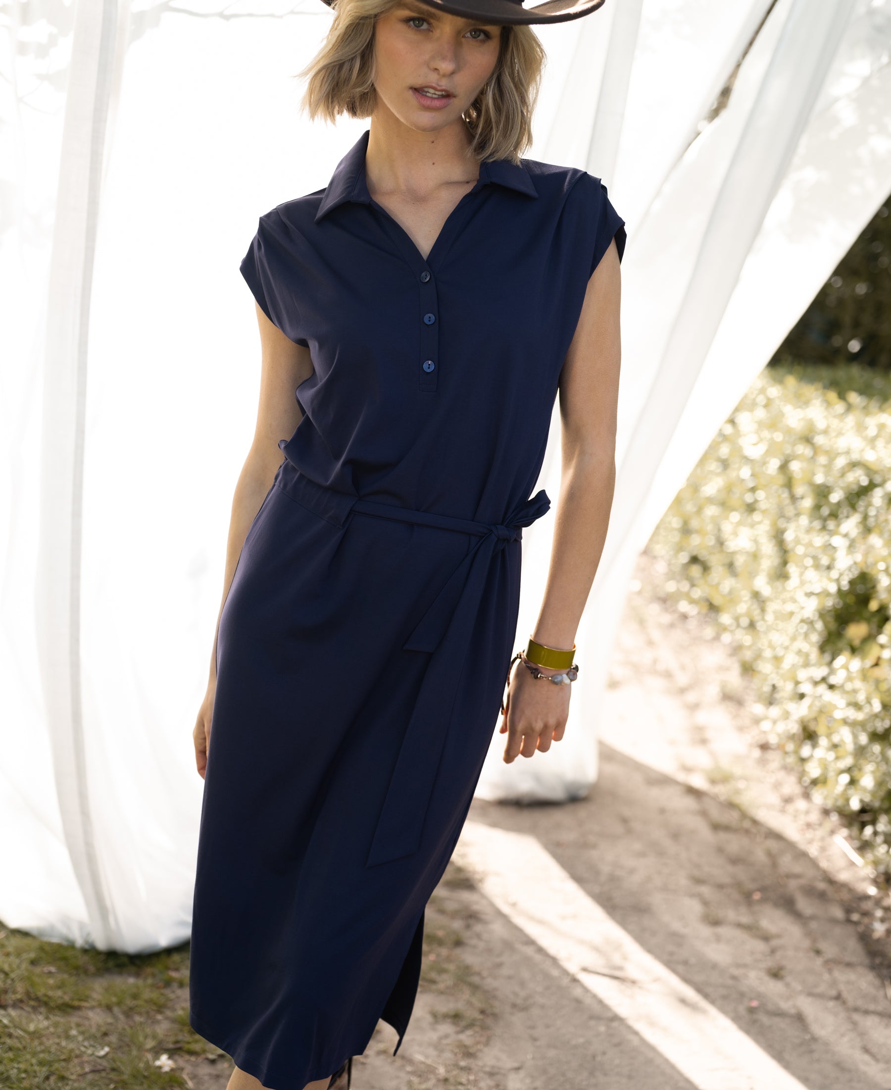 Travel polo dress INES in dark blue by PLEIN PUBLIQUE shown outdoors, front view.