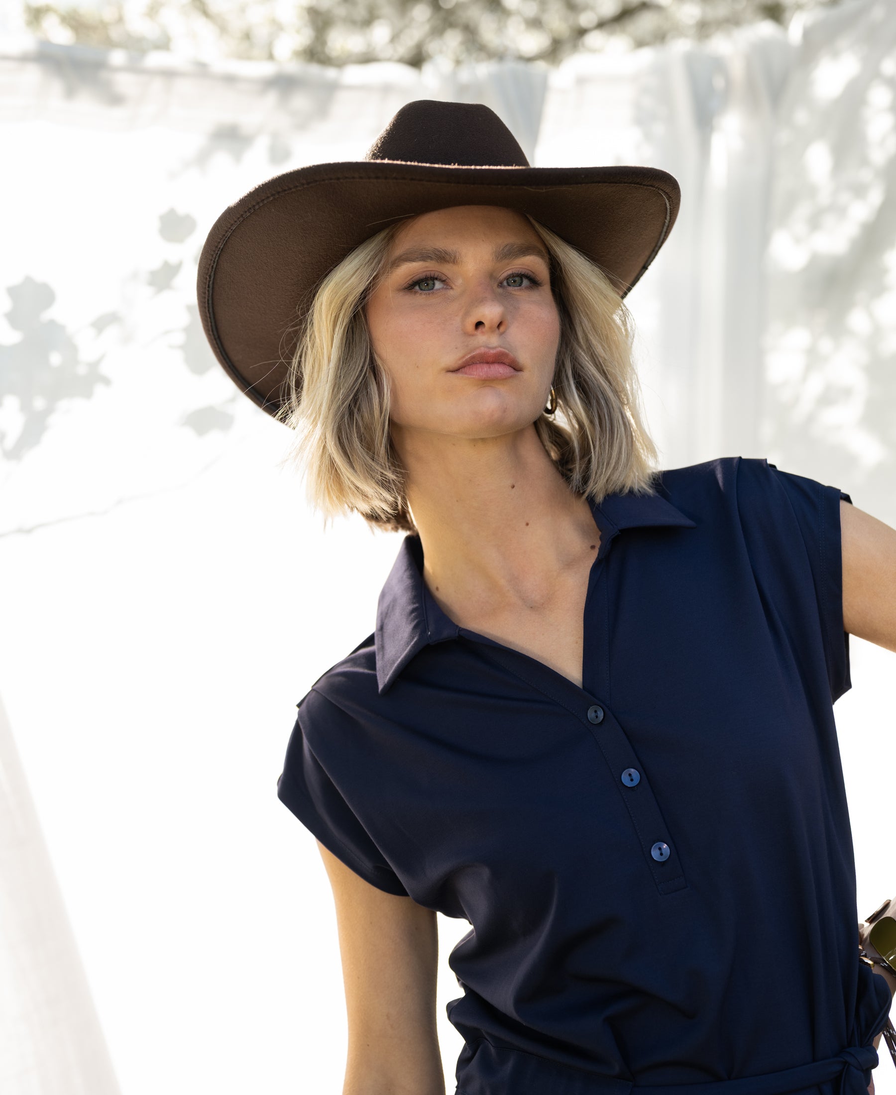 Navy blue travel polo dress by PLEIN PUBLIQUE photographed outdoors.