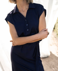 Navy PLEIN PUBLIQUE INES travel polo dress shown outdoors in soft sunlight.
