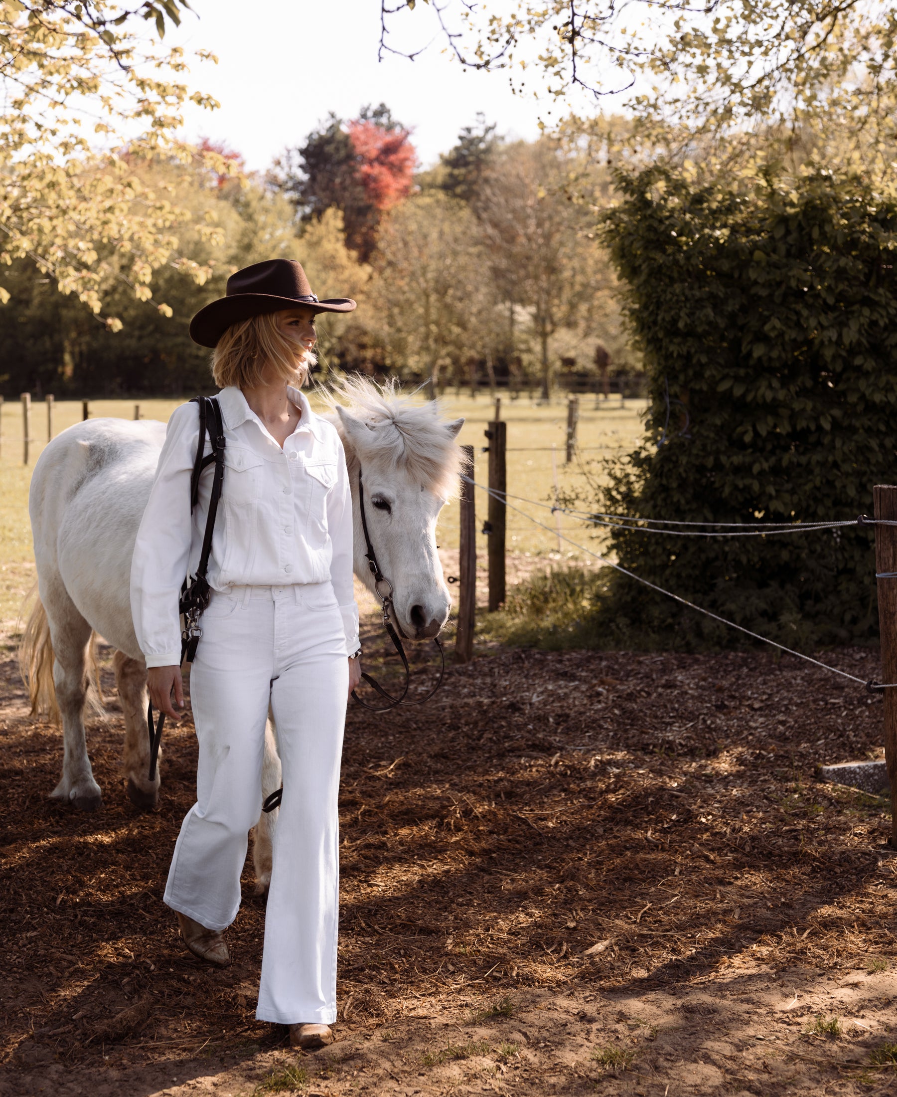 Wide leg white jeans by PLEIN PUBLIQUE shown outdoors on a sunny day.