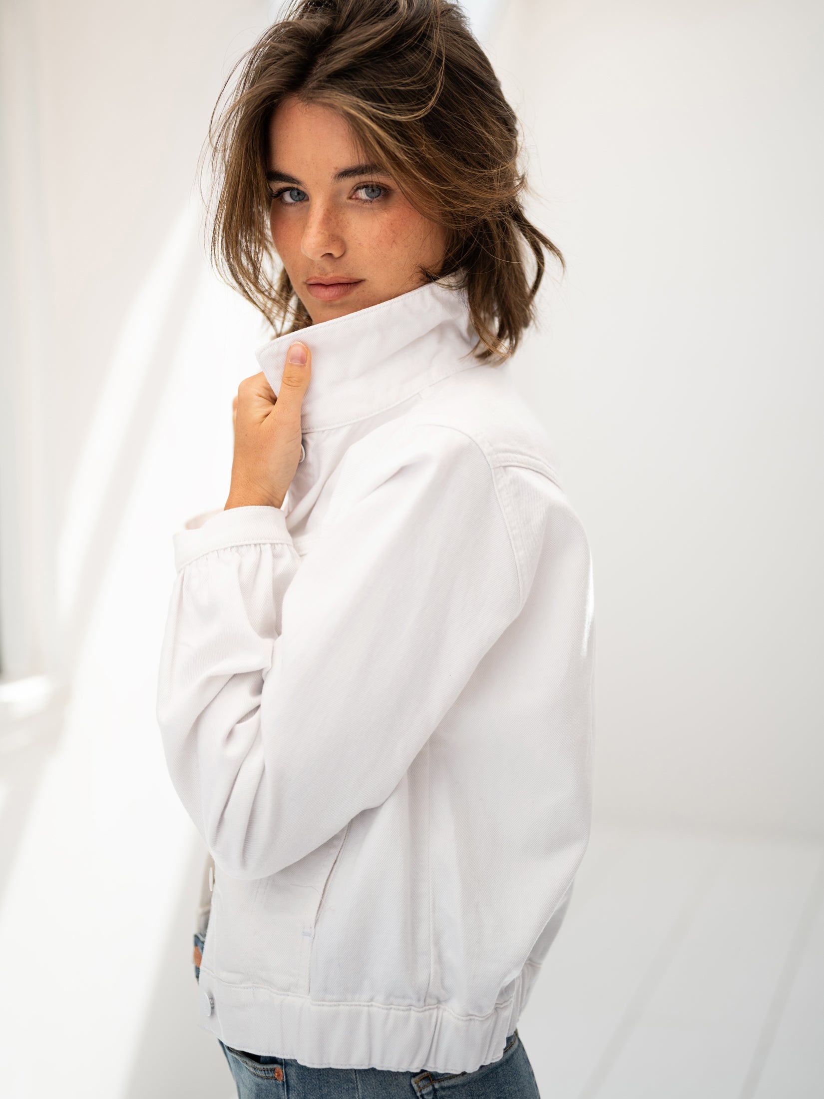 White denim jacket by PLEIN PUBLIQUE, shown on a model with light brown hair in a bright room.