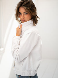 White denim jacket by PLEIN PUBLIQUE, shown on a model with light brown hair in a bright room.