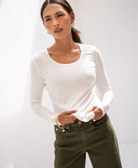 Woman wears ivory Lyocell long sleeve LA JAMALA T-shirt, hands in pockets.