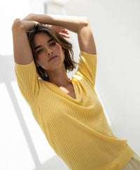 Yellow LE JASMIN Tencel-silk polo shirt displayed in a sunlit room.