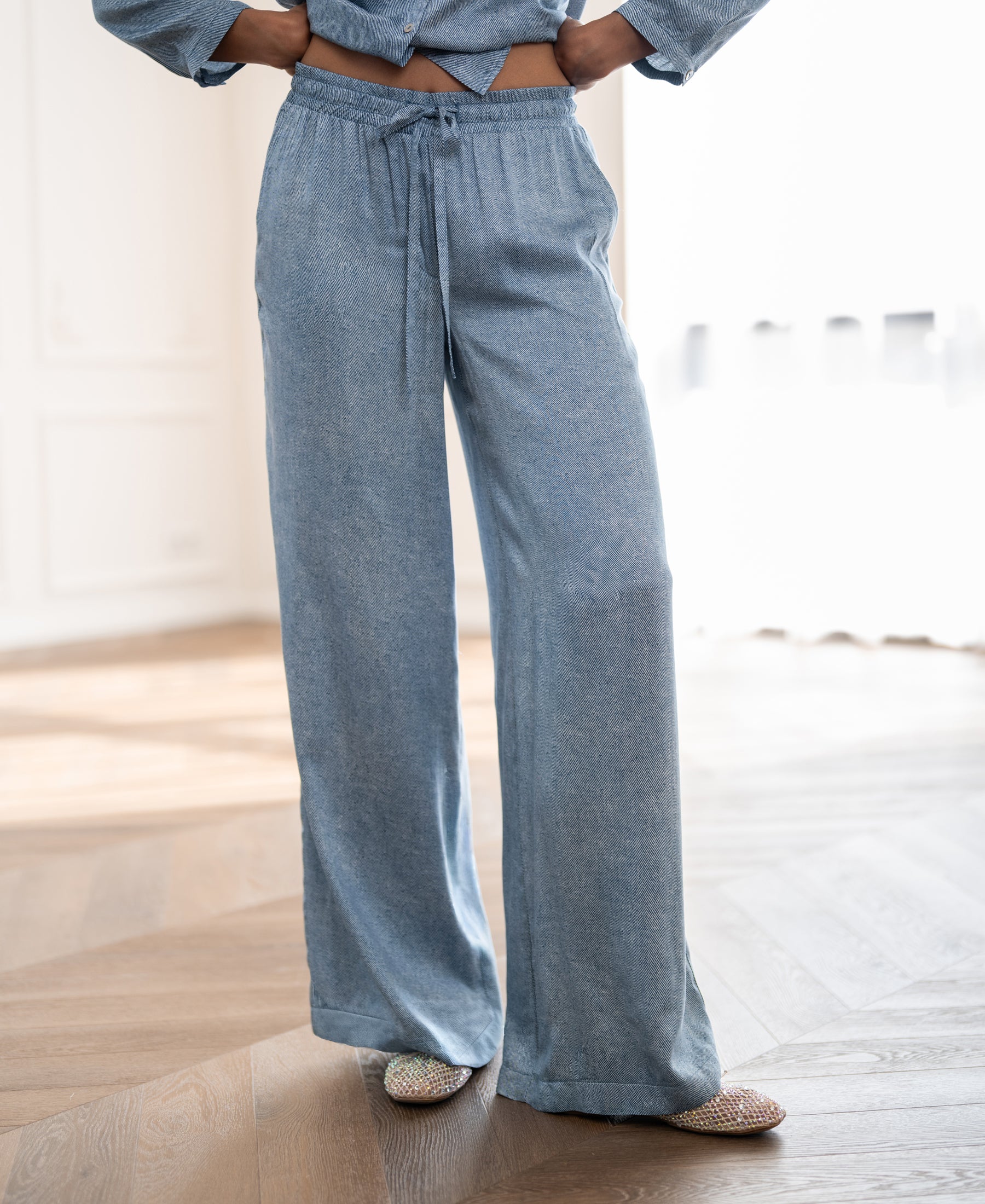 PLEIN PUBLIQUE summer trousers with jeans print displayed on wooden floor in a bright room.