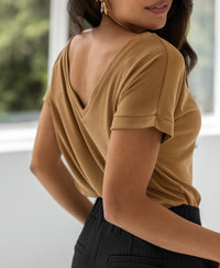 Light camel T-shirt with "La Julien" graphic, shown from the back indoors. Model stands facing away from the window.