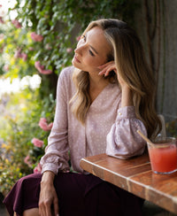 Front view of the PLEIN PUBLIQUE wrap blouse in dusty pink with ivory polka dots.
