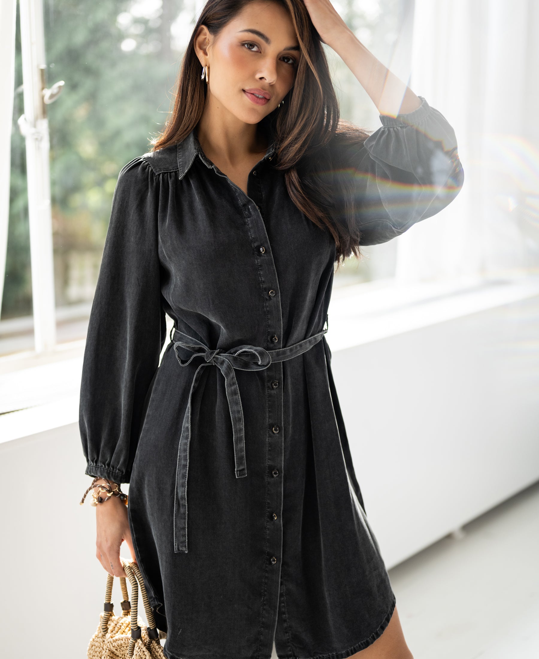 Charcoal Tencel shirt dress in view, shown standing by a window.
