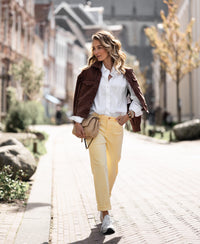 Woman wearing the Oversized LE LILLE white blouse on a sunny street.
