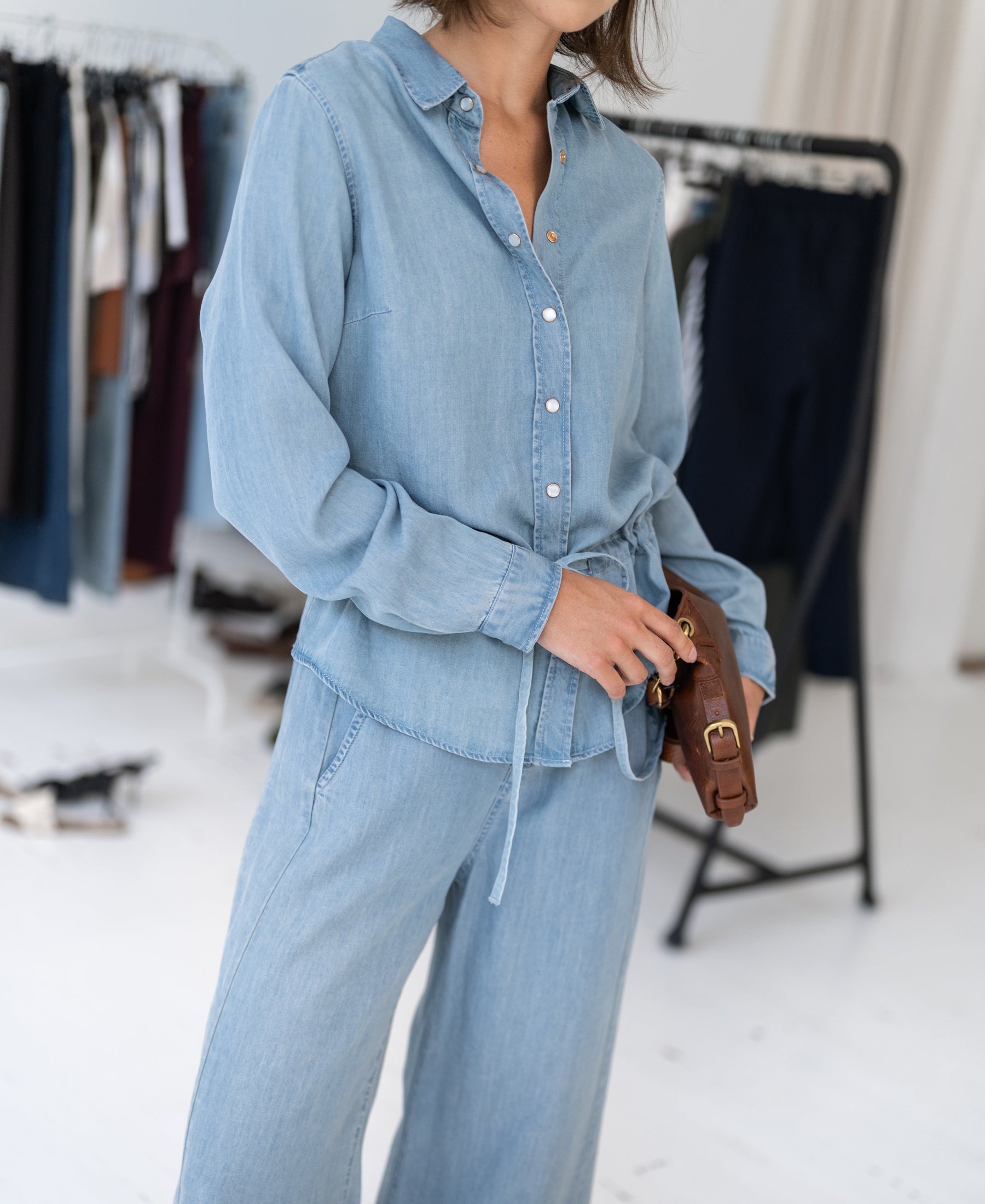 Woman wearing a bleached Tencel denim blouse in-store.