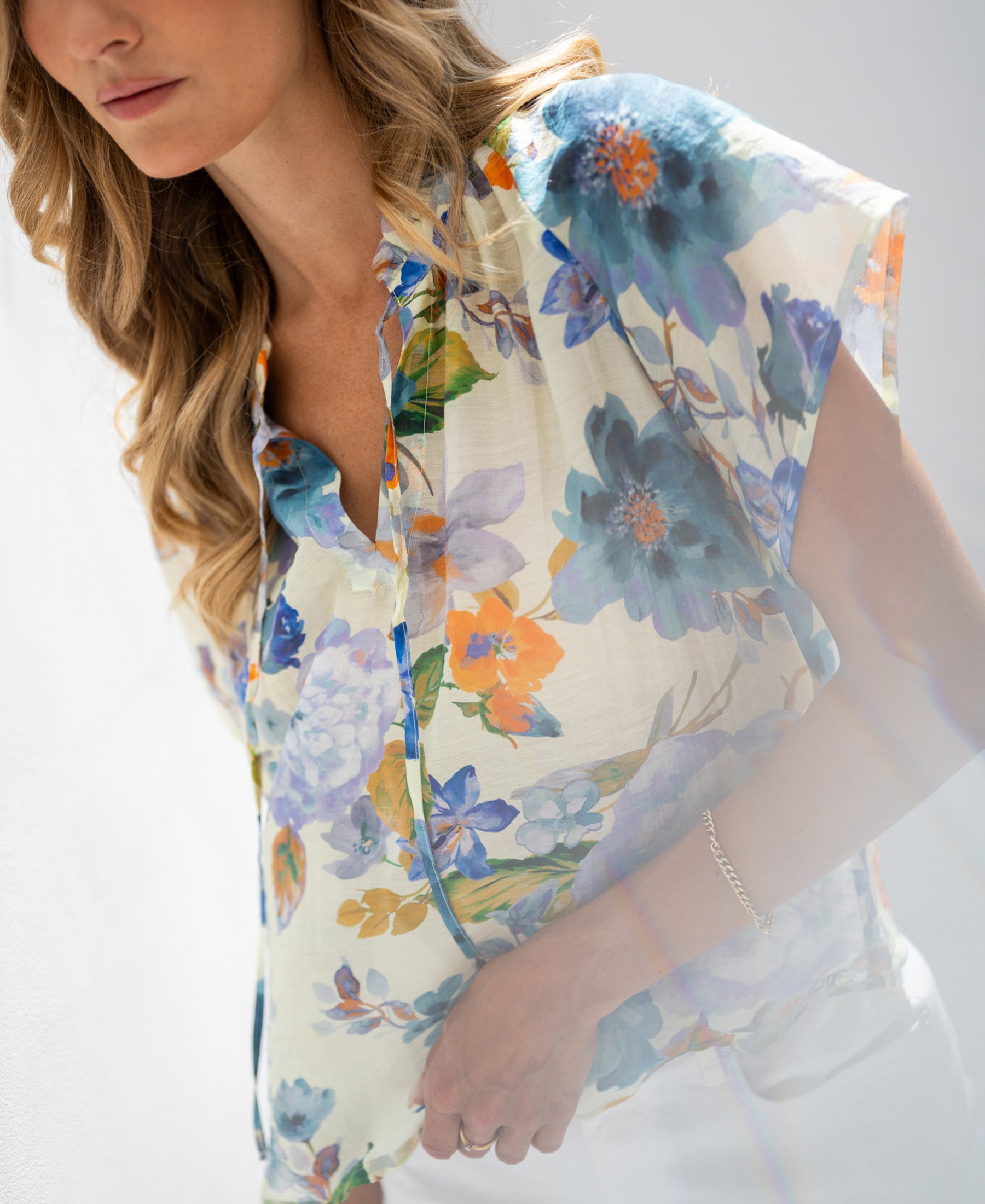 Light blue floral print blouse top, partially cropped, front view.