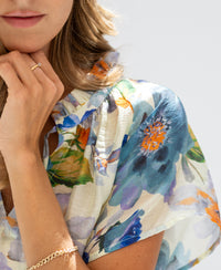 Light blue floral print blouse top with butterfly sleeves, shown in soft lighting.