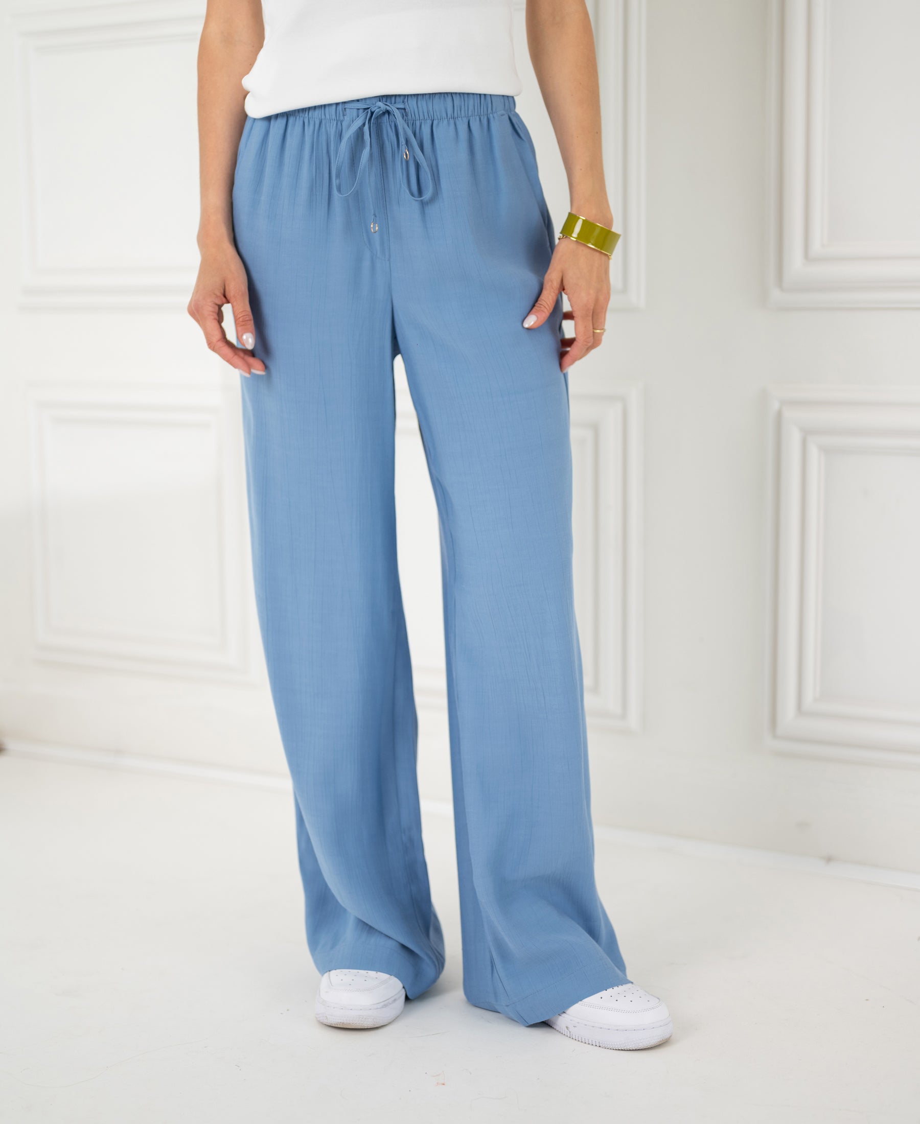 Person wearing light blue jeans-style pants indoors.