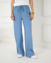 Person wearing light blue jeans-style pants indoors.