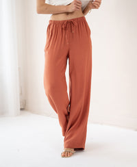 Wide leg terra-colored pants in soft fabric, shown indoors against a white background.