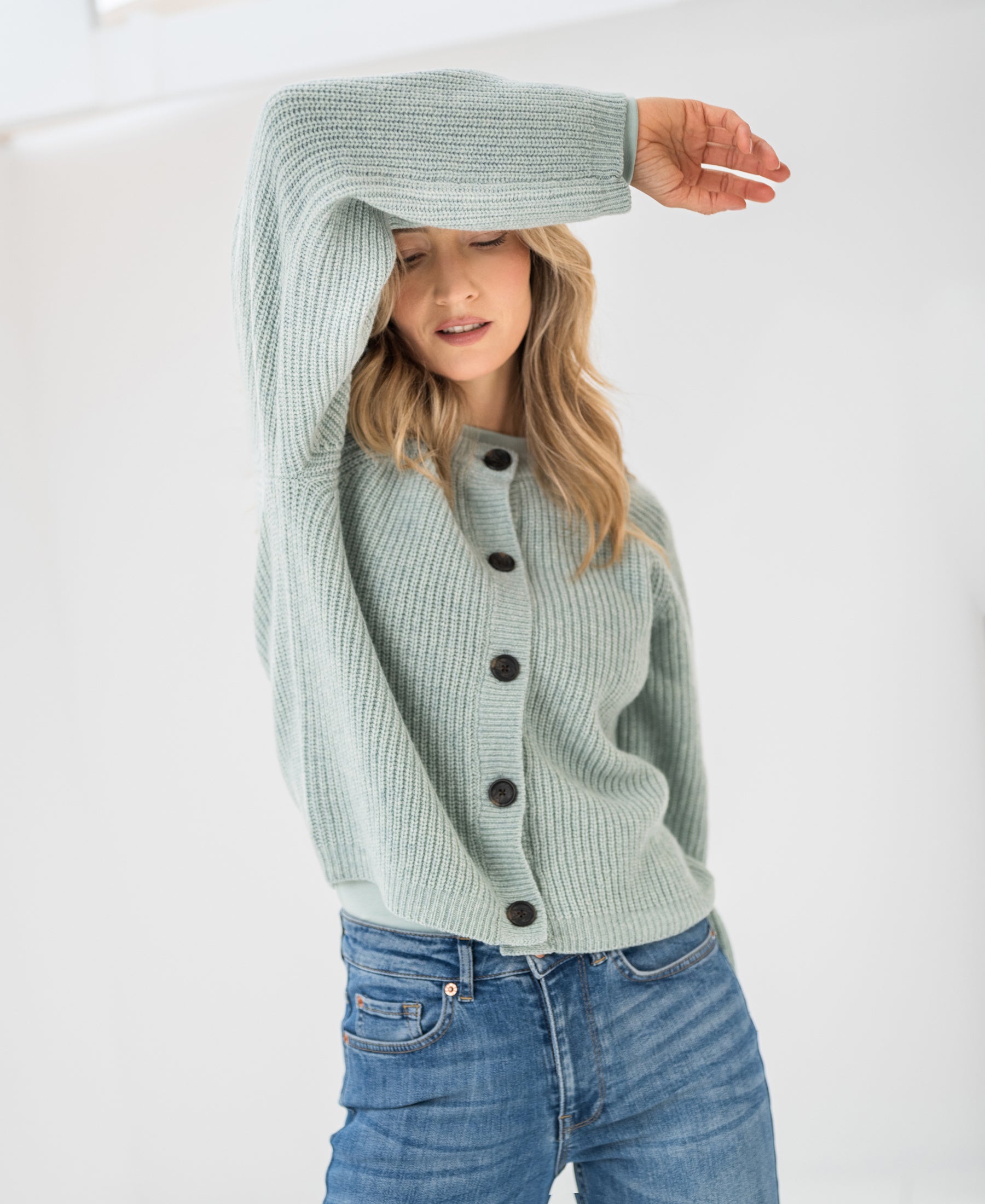 Mist green Merino wool vest, front view, shown in bright lighting.