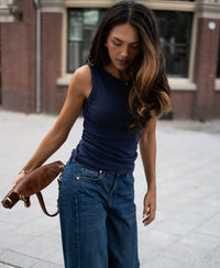 Navy blue luxe and soft boatneck top in a sidewalk setting.