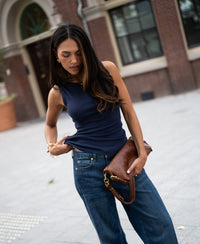 Woman wearing a luxe & soft dark blue boat neck top by PLEIN PUBLIQUE.