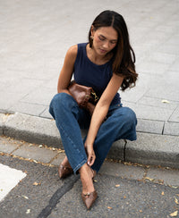 Woman wearing luxe and soft boat neck top Le Lys by Plein Publique, standing outdoors.