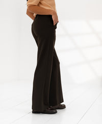 PLEIN PUBLIQUE chalk stripe trousers LE MALO in dark brown shown worn by a model standing in a bright room.