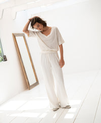 Cream silk blend top with kimono sleeves, shown on a woman standing near a large mirror in a bright room.