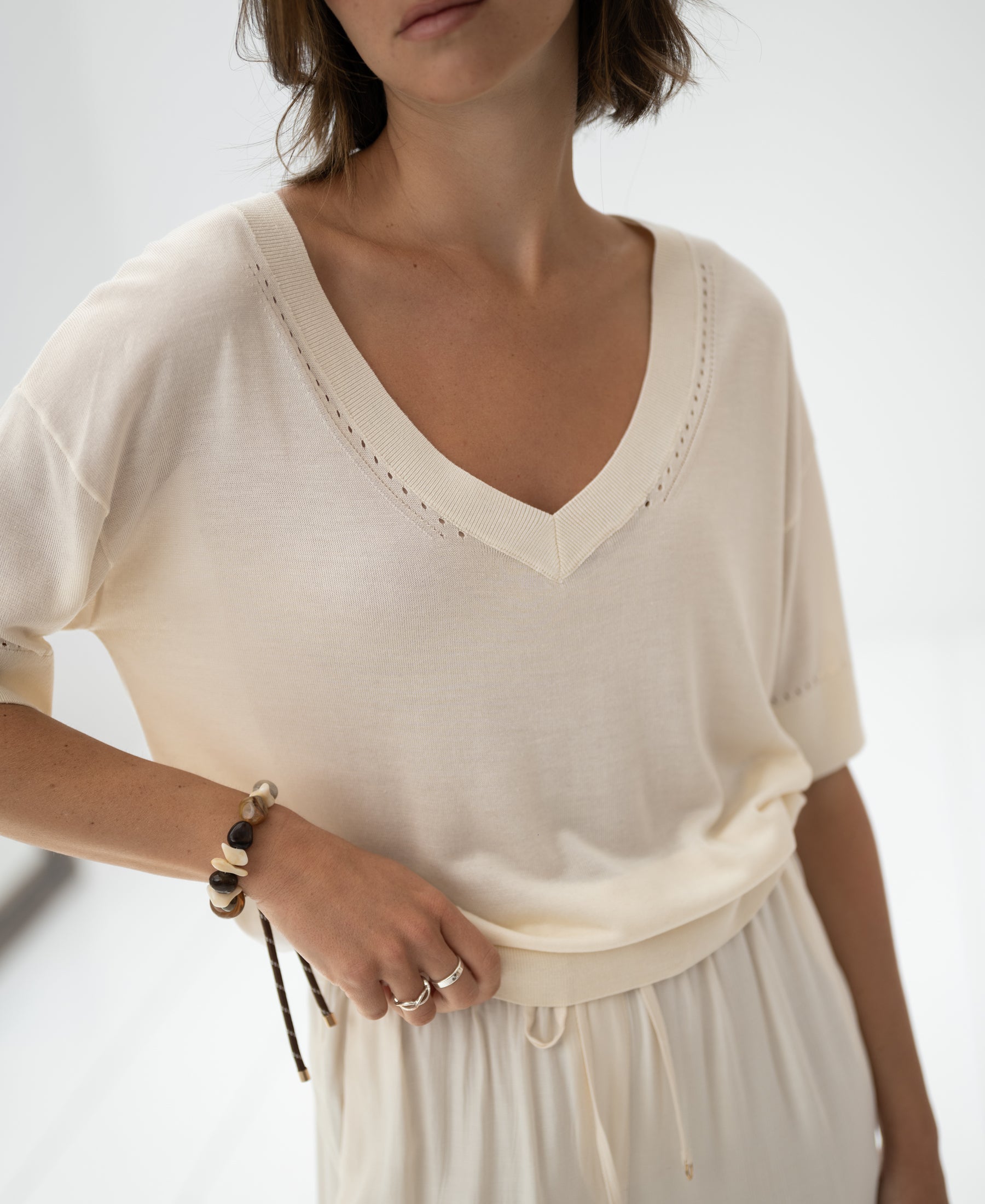 Woman wearing the LE MARDY Cream silk top by PLEIN PUBLIQUE in soft natural light.
