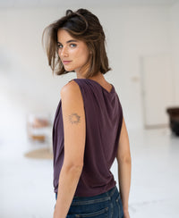 Woman wears burgundy Plein Publique top with buckle detail.