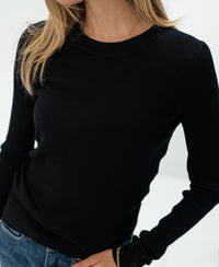Black Luxe merino shirt by PLEIN PUBLIQUE, shown on a woman with one hand in her pocket.